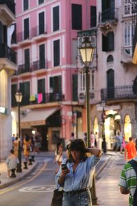 Woman walking on city street at night