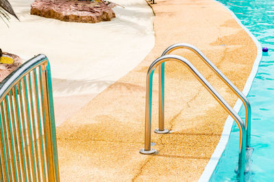 High angle view of empty chairs by swimming pool