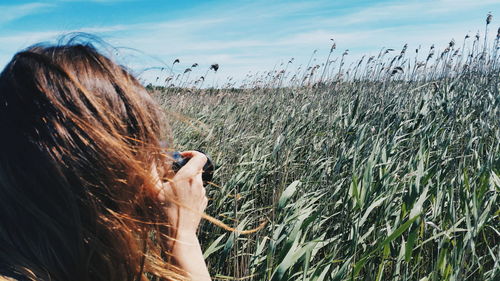 Girl taking photo of a windy field