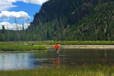 Man standing by lake against sky