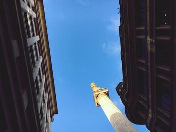 Low angle view of historic column against blue sky