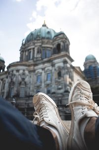 Low section of man wearing shoes against berlin cathedral