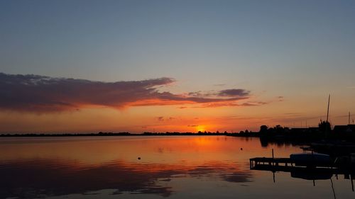 Silhouette of boats in lake during sunset