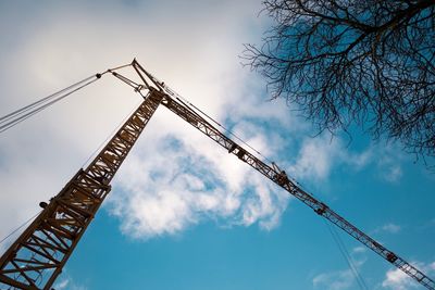 Low angle view of cranes against sky