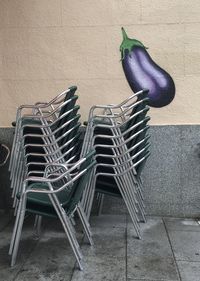 Empty chairs on table against wall