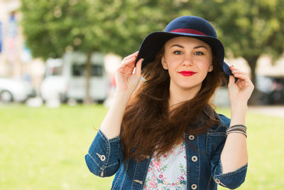 Portrait of beautiful woman wearing hat on field