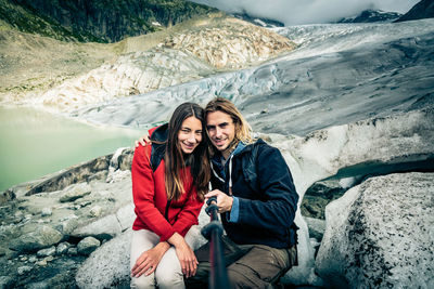 Woman smiling while standing on snow covered mountains