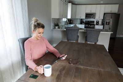 Woman sitting on table at home