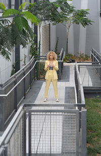 Portrait of young woman sitting on railing