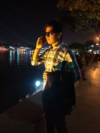 Full length of man standing on illuminated city at night