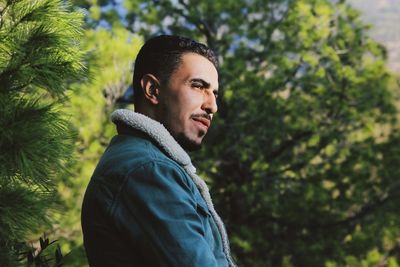 Portrait  young man looking trees 