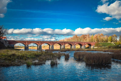 Arch bridge over river against sky