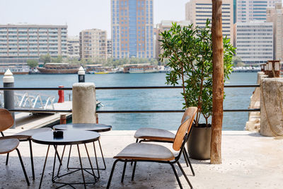 An outdoor cafe overlooking the dubai creek water canal with the deira district in the background