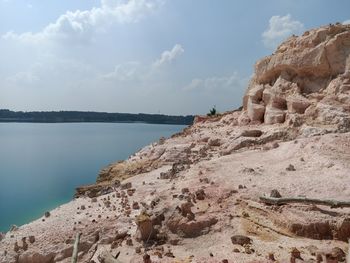 Rock formations on shore against sky