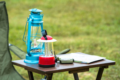 Lantern with navigational compass and map on table