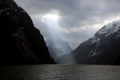 Scenic view of lake by mountains against sky