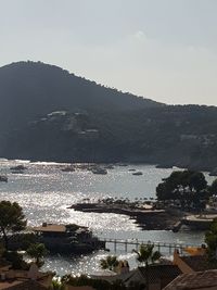 High angle view of city by sea against sky