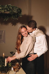 A man and a woman in love at a romantic dinner give each other gifts for christmas in the evening