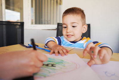 Close-up of cute boy drawing at home