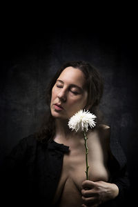 Woman in melancholic attitude with white chrysanthemum ix