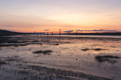 View of the st. lawrence river at low tide, and the island of orleans bridge seen during sunrise