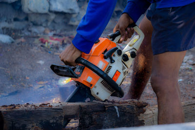 Low section of man working on motorcycle