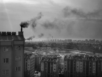 Smoke emitting from factory against sky