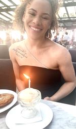 Portrait of a smiling young woman sitting on table