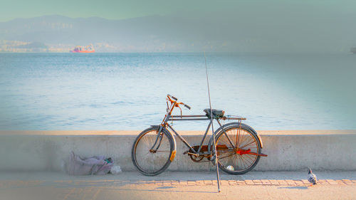 Bicycle on beach against sky