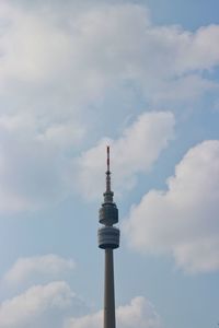 Low angle view of communications tower and building against sky