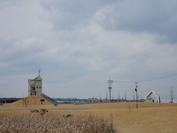 Electricity pylon on field against sky