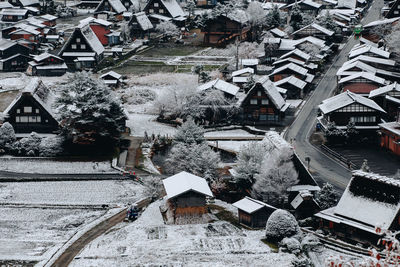 High angle view of snow covered houses in city