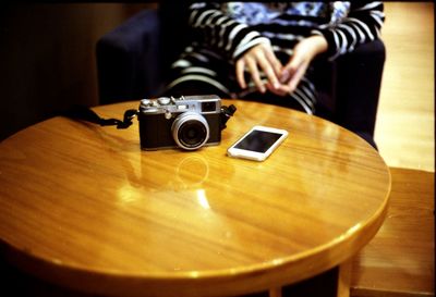 Midsection of person using smart phone on table