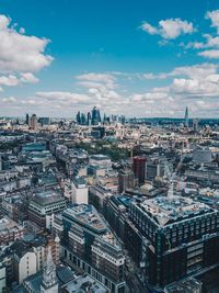 High angle view of city buildings against cloudy sky