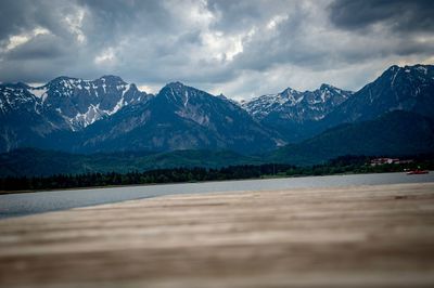 Scenic view of lake and mountains against cloudy sky