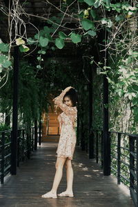 Portrait of woman standing against trees