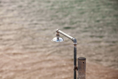 Close-up of padlocks on railing against wall