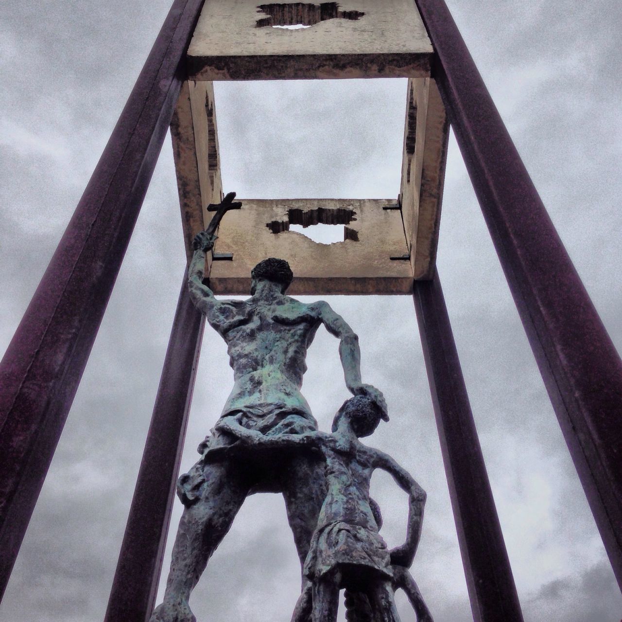 low angle view, sky, built structure, architecture, human representation, metal, sculpture, art and craft, art, railing, cloud - sky, day, statue, creativity, metallic, cloud, outdoors, no people, building exterior