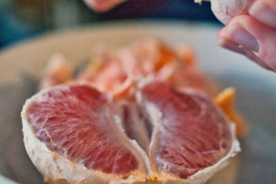 Close-up of hand holding grapefruit at cozy home 