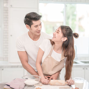 Young couple standing in kitchen at home