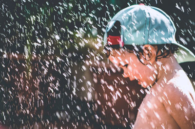 Shirtless cute boy enjoying rain