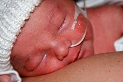 Close-up of baby lying on woman