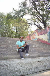 Portrait of young man sitting on staircase