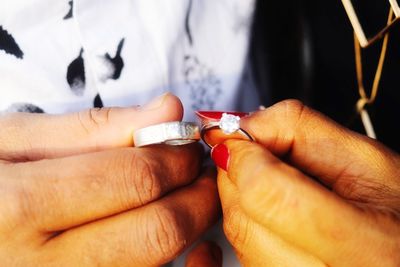 Close-up of couple hands holding rings