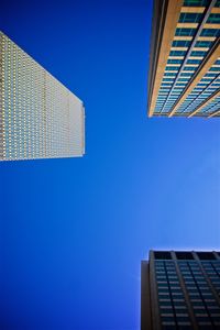 Low angle view of modern buildings against clear blue sky