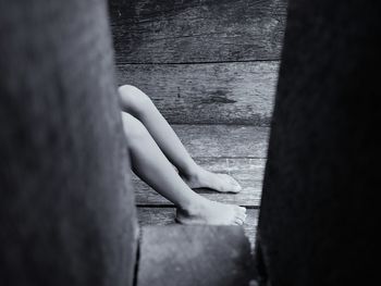 Low section of woman sitting on hardwood floor