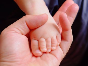 Cropped image of mother holding baby leg