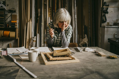 Side view of woman sitting on table