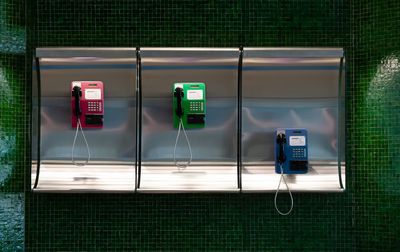 Multi colored telephones on wall