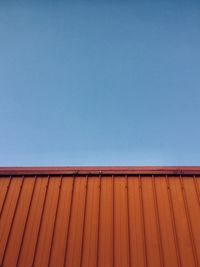 Low angle view of wooden roof against clear blue sky